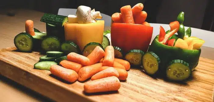 sliced carrots and green bell pepper on brown wooden chopping board